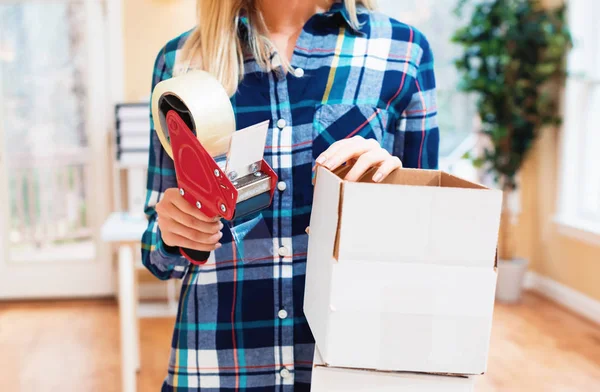 Młoda kobieta pakująca pudełka do wysyłki — Zdjęcie stockowe