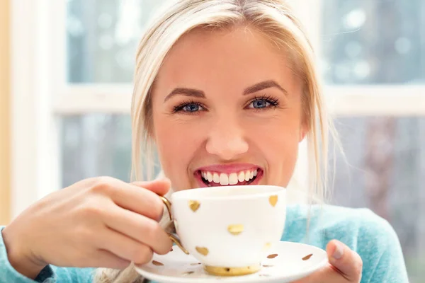 Glückliche junge Frau trinkt Kaffee — Stockfoto