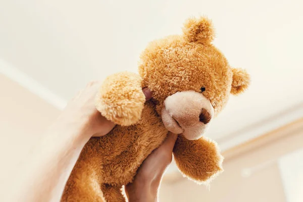 Holding up a teddy bear in the air — Stock Photo, Image