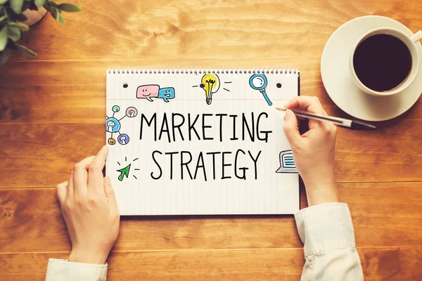 Texto de estratégia de marketing com uma pessoa segurando uma caneta — Fotografia de Stock