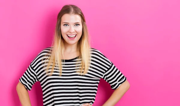 Mujer joven feliz con fondo rosa — Foto de Stock