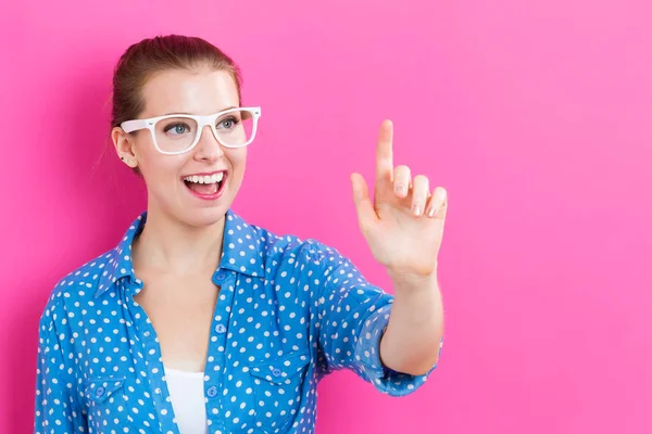 Gelukkig jonge woman wijzend iets — Stockfoto