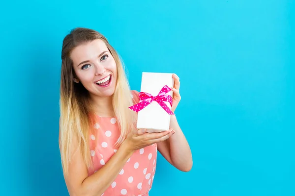 Joyeux jeune femme tenant une boîte cadeau — Photo