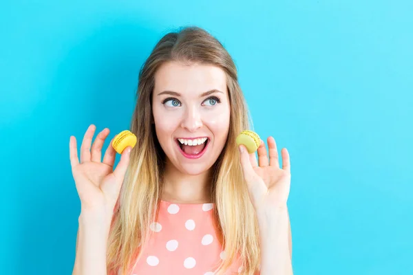 Jovem feliz segurando macarons — Fotografia de Stock