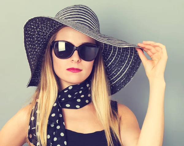 Mutlu genç kadın bir şapka ve güneş gözlüğü takıyor — Stok fotoğraf