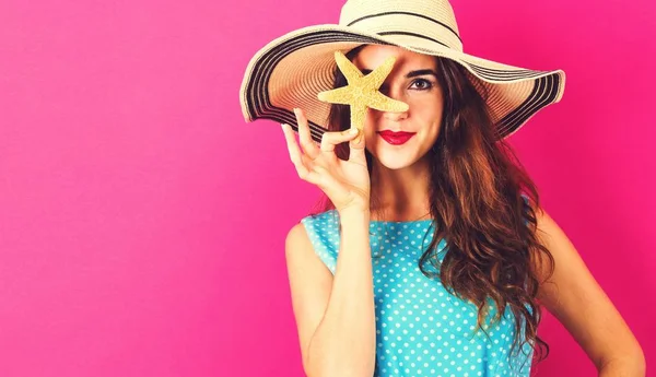 Happy young woman holding a starfish — Stock Photo, Image