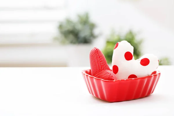 Almofadas de coração em um prato de coração vermelho — Fotografia de Stock