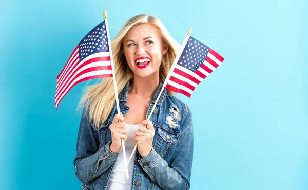 Mujer sosteniendo banderas americanas — Foto de Stock