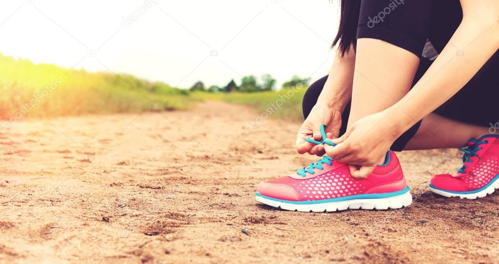 runner tying her running shoes 