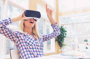 Sanal gerçeklik kulaklığı kullanan kadın