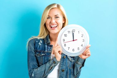  Saati yaklaşık 12 gösteren tutan kadın