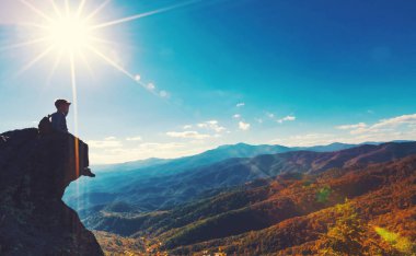 Bakan bir uçurumun kenarında oturan adam