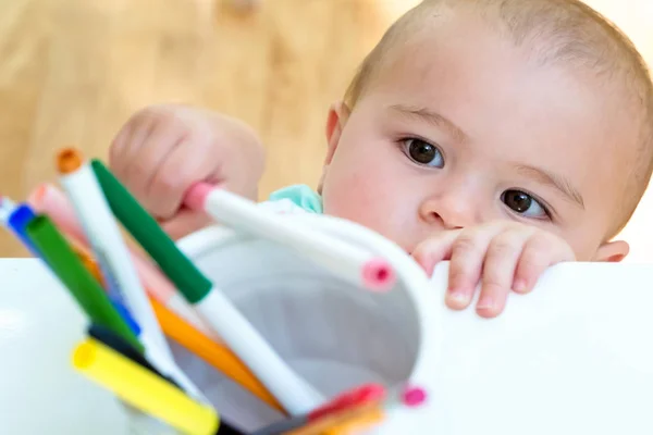 Toddler girl reaching for markers — Stock Photo, Image