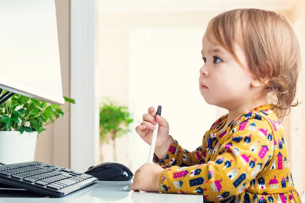 Toddler poważnie patrząc na jej ekran komputera — Zdjęcie stockowe