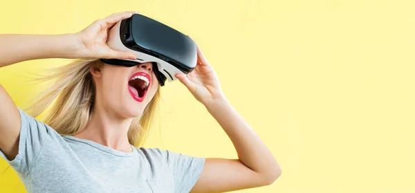 Młoda kobieta korzystająca z zestawu słuchawkowego wirtualnej rzeczywistości — Zdjęcie stockowe