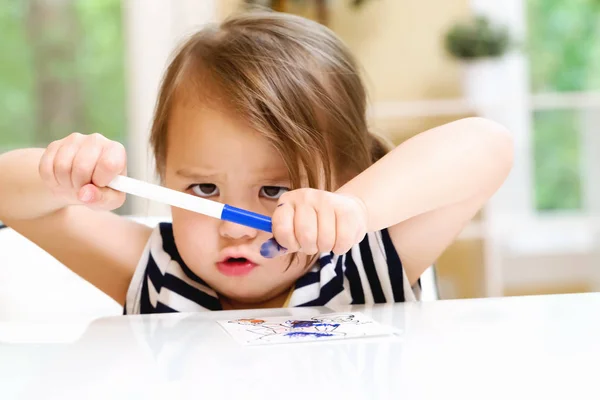Toddler girl opening a marker — Stock Photo, Image