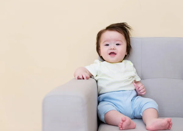 Μωρό αγόρι κάθεται σε έναν καναπέ — Φωτογραφία Αρχείου