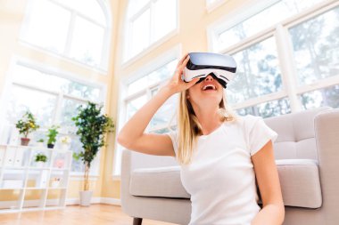 Sanal gerçeklik kulaklığı kullanan genç bir kadın.