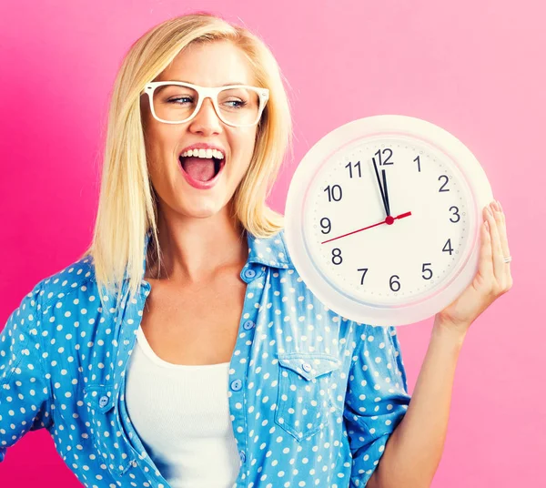 Mujer sosteniendo reloj mostrando casi 12 — Foto de Stock