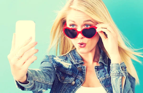 Ung kvinna som tar en selfie — Stockfoto
