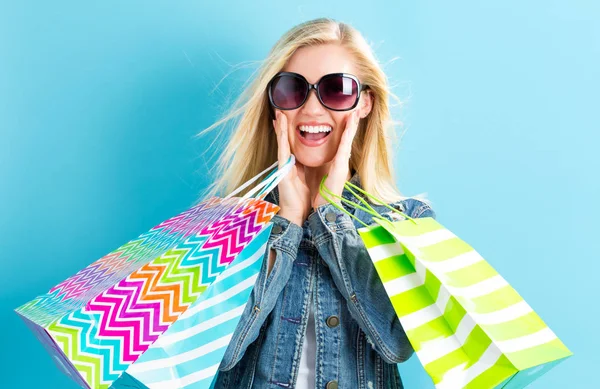 Szczęśliwa młoda kobieta trzyma torby na zakupy — Zdjęcie stockowe