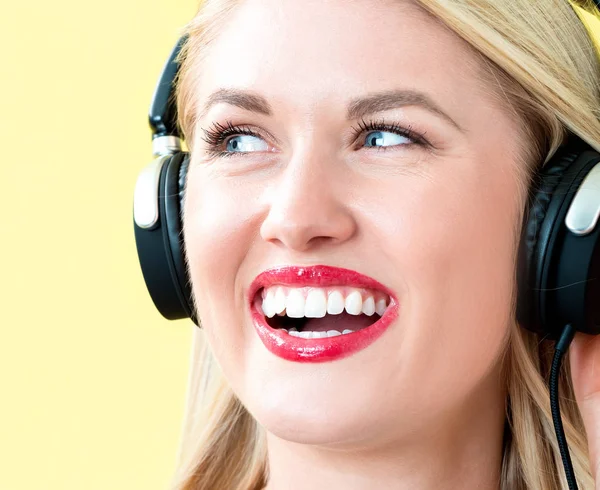 Šťastná mladá žena se sluchátky — Stock fotografie