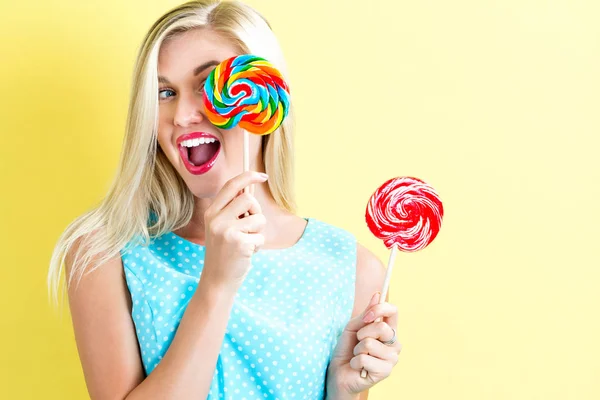 Jonge vrouw bedrijf lollies — Stockfoto