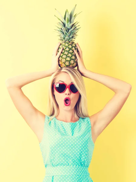 Joyeux jeune femme tenant un ananas — Photo