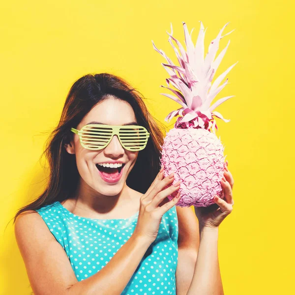 Šťastná mladá žena držící ananas — Stock fotografie