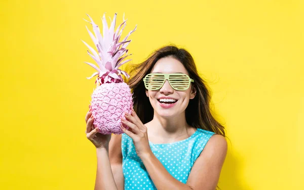 Šťastná mladá žena držící ananas — Stock fotografie