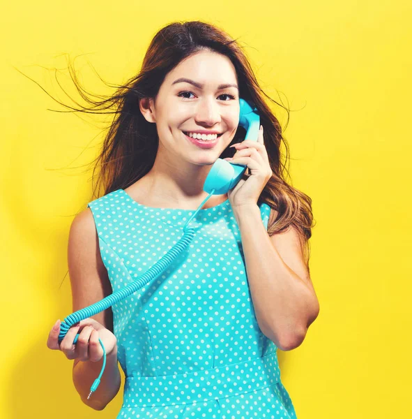 Giovane donna che parla sul vecchio telefono di moda — Foto Stock