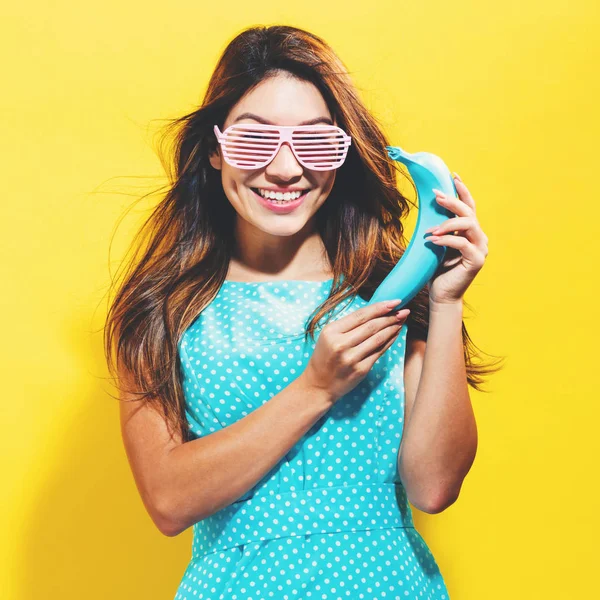 Mujer joven feliz sosteniendo un plátano de color —  Fotos de Stock