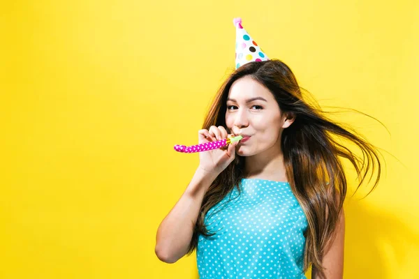 Young woman with party hat with noisemaker — Stock Photo, Image