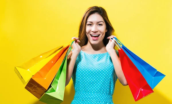 Glad ung kvinna som håller i shoppingväskor — Stockfoto