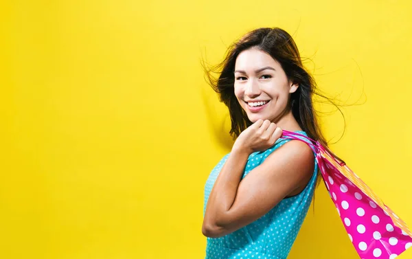 Šťastná mladá žena drží nákupní tašku — Stock fotografie