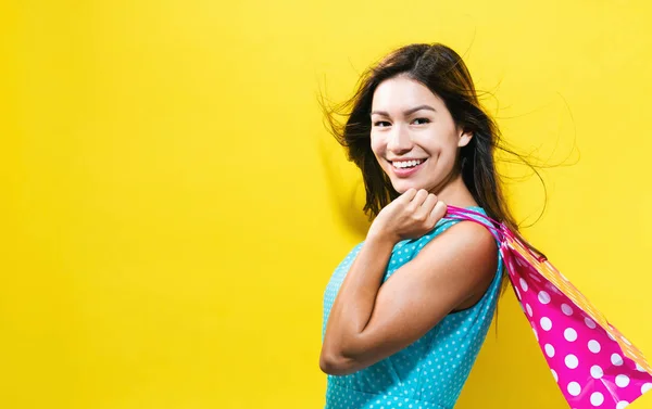 Happy young woman holding a shopping bag — Stock Photo, Image