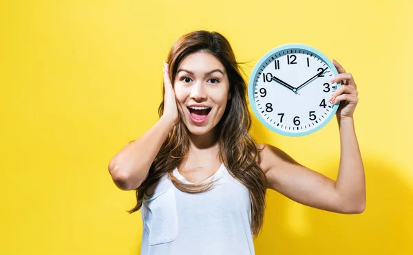 Young woman holding a clock — Stock Photo, Image