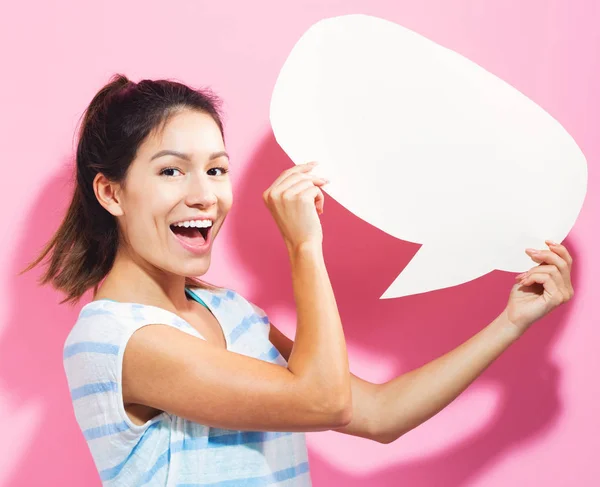 Mujer joven sosteniendo una burbuja del discurso — Foto de Stock