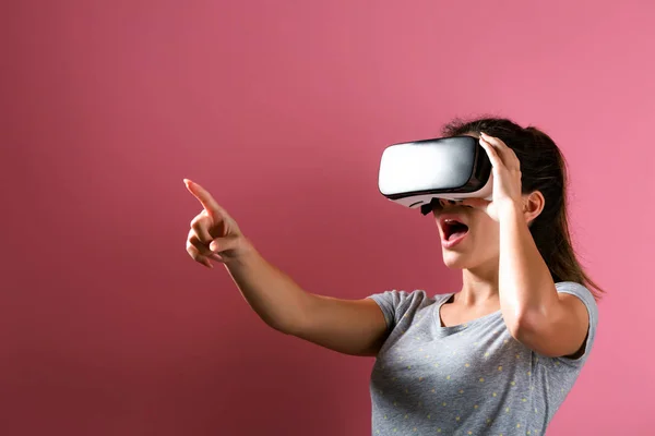 Jovem mulher usando fone de ouvido realidade virtual — Fotografia de Stock