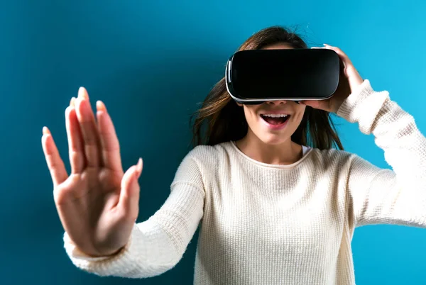 Jovem mulher usando fone de ouvido realidade virtual — Fotografia de Stock