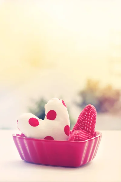 Heart cushions in a red heart dish — Stock Photo, Image