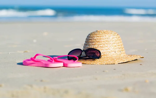 Słomkowy kapelusz i okulary przeciwsłoneczne na plaży — Zdjęcie stockowe