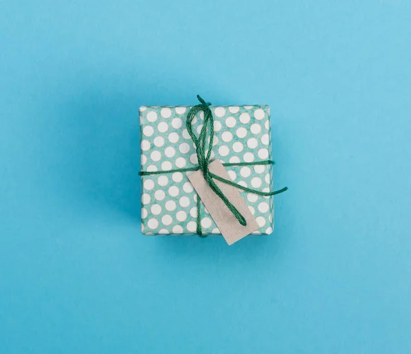 Pequeña caja de regalo hecha a mano sobre un fondo azul — Foto de Stock