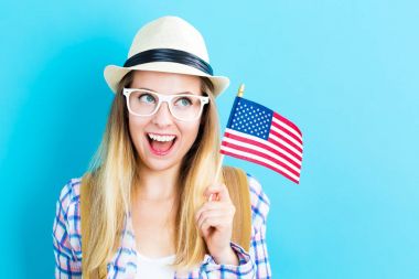 Amerikan bayrağı tutan mutlu genç seyahat kadın