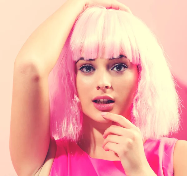 Hermosa mujer en una peluca rosa brillante — Foto de Stock