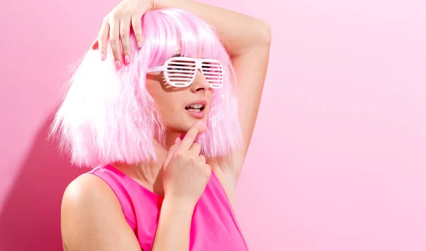 Hermosa mujer en una peluca rosa brillante — Foto de Stock