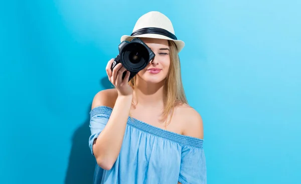 Mujer joven sosteniendo una cámara — Foto de Stock