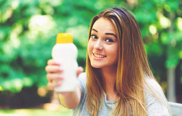 Güneş kremi şişe bir genç kadın — Stok fotoğraf