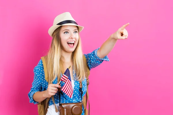 Happy young traveling woman holding American flag — Stock Photo, Image