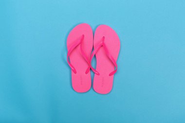 Mavi bir arka plan üzerinde plaj sandaletleri